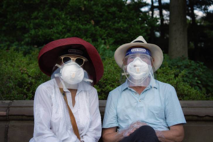 A photo of two people decked out in face shields and masks in Central Park